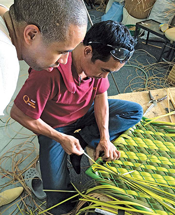 Burks, with a weaver in the Philippines, develops a pattern for Dedon's Dala line.