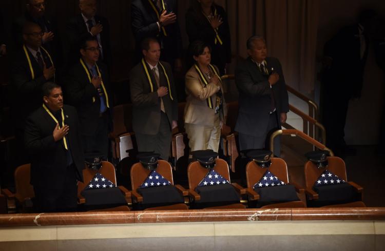 Five seats at the memorial service have a flag and a hat in memory of the five police officers who died.